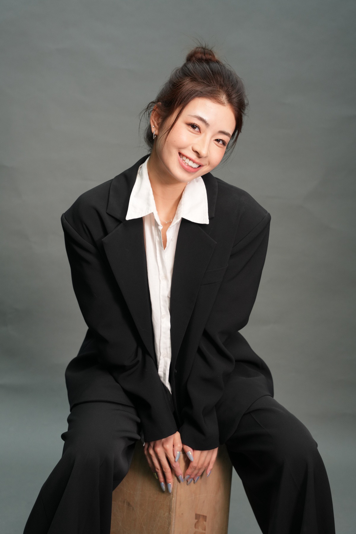 Amy Wang, seated portrait in a black suit